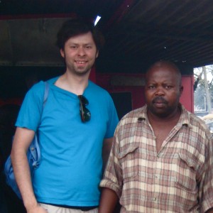 Manuel Marindze und ich vor seinem Imbissstand auf dem Markt von Xipamanine in Maputo, wo seine Frau und er Broiler mit Pommes verkaufen